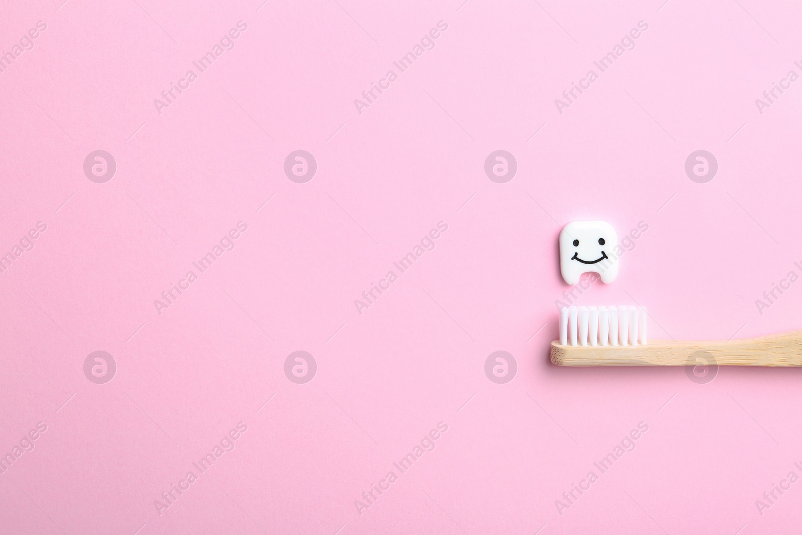 Photo of Small plastic tooth, wooden brush and space for text on color background, flat lay