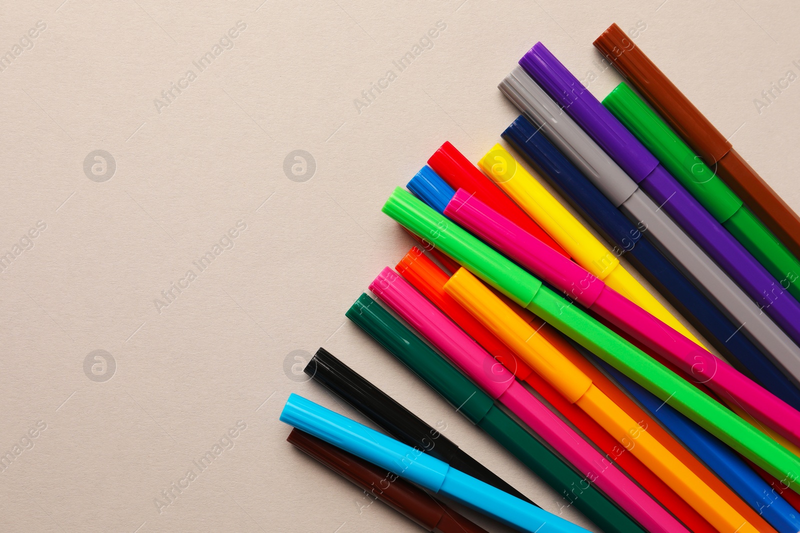 Photo of Many bright markers on light grey background, flat lay. Space for text