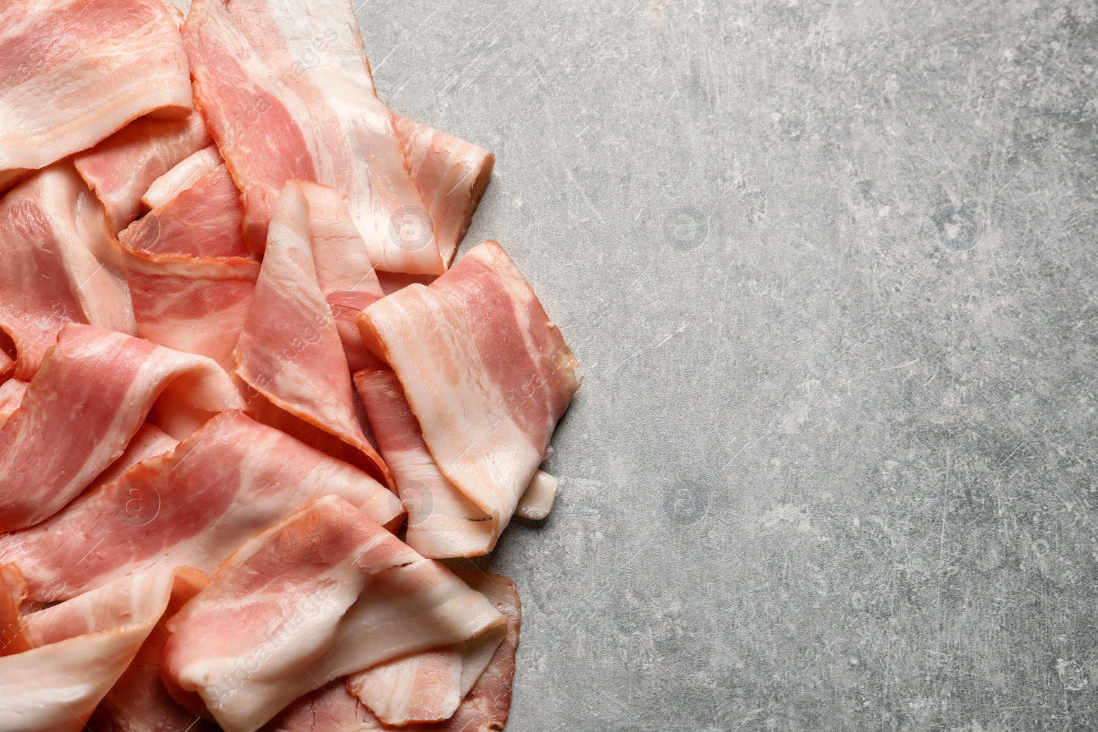 Photo of Raw bacon rashers on grey background