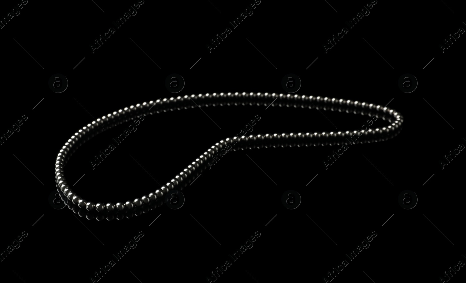 Photo of Chain of small magnetic balls on black background