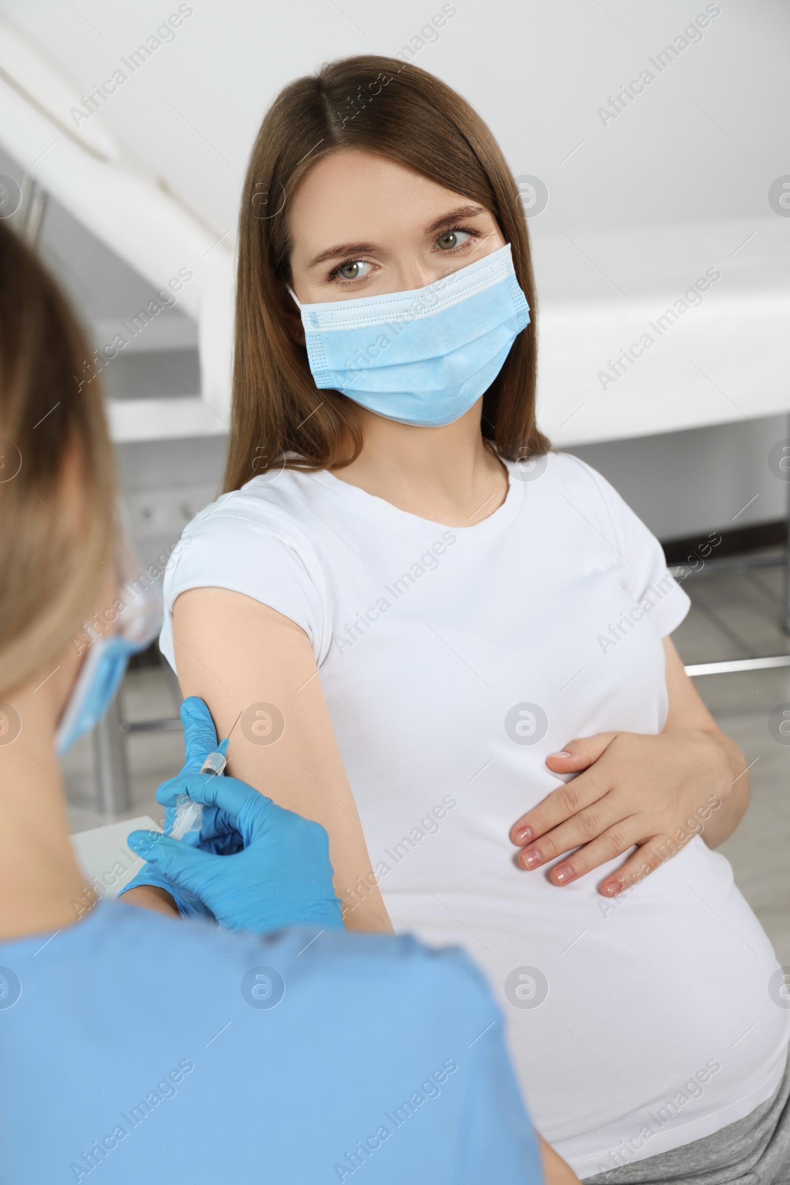 Photo of Doctor giving injection to pregnant woman in hospital