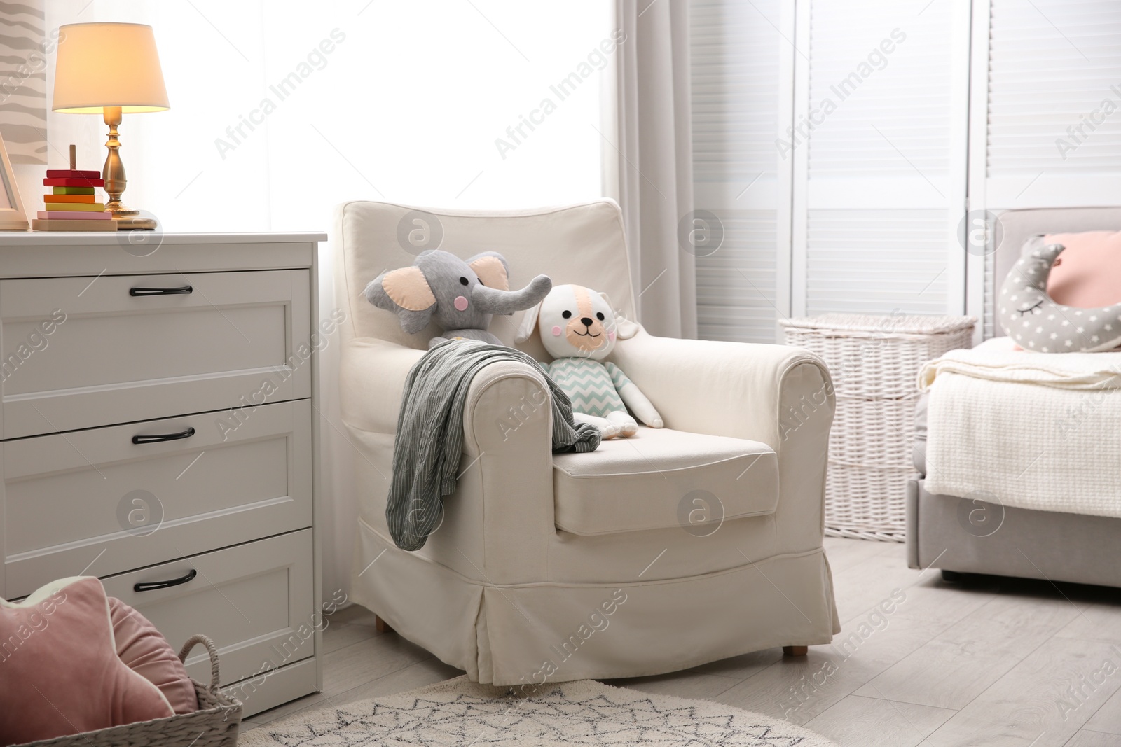 Photo of Comfortable armchair in modern baby room interior