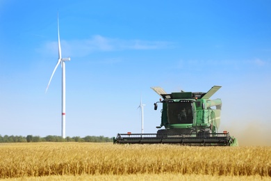 Modern combine harvester working in agricultural field