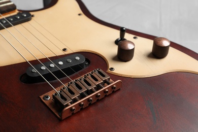 Photo of Modern electric guitar on color background, closeup view