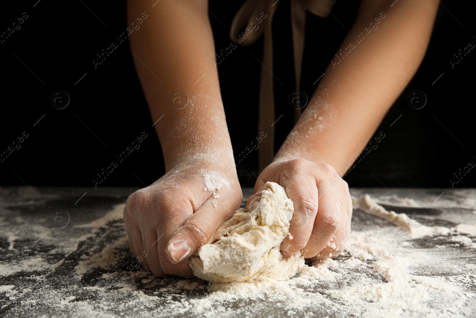 Photo of Woman kneading dough for pizza at grey table, closeup