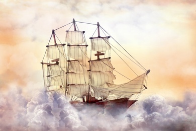 Dream world. Sailing ship floating among wonderful fluffy clouds
