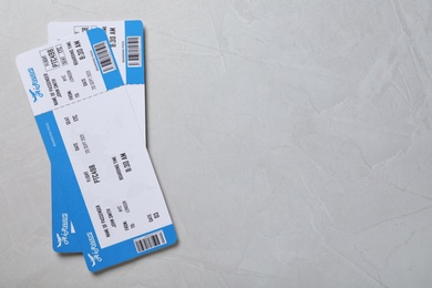 Tickets on light grey background, flat lay with space for text. Travel agency concept