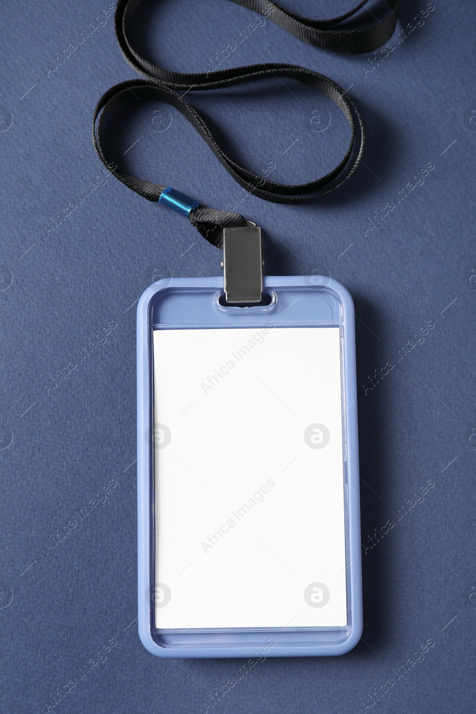 Photo of Blank badge with string on blue background, top view