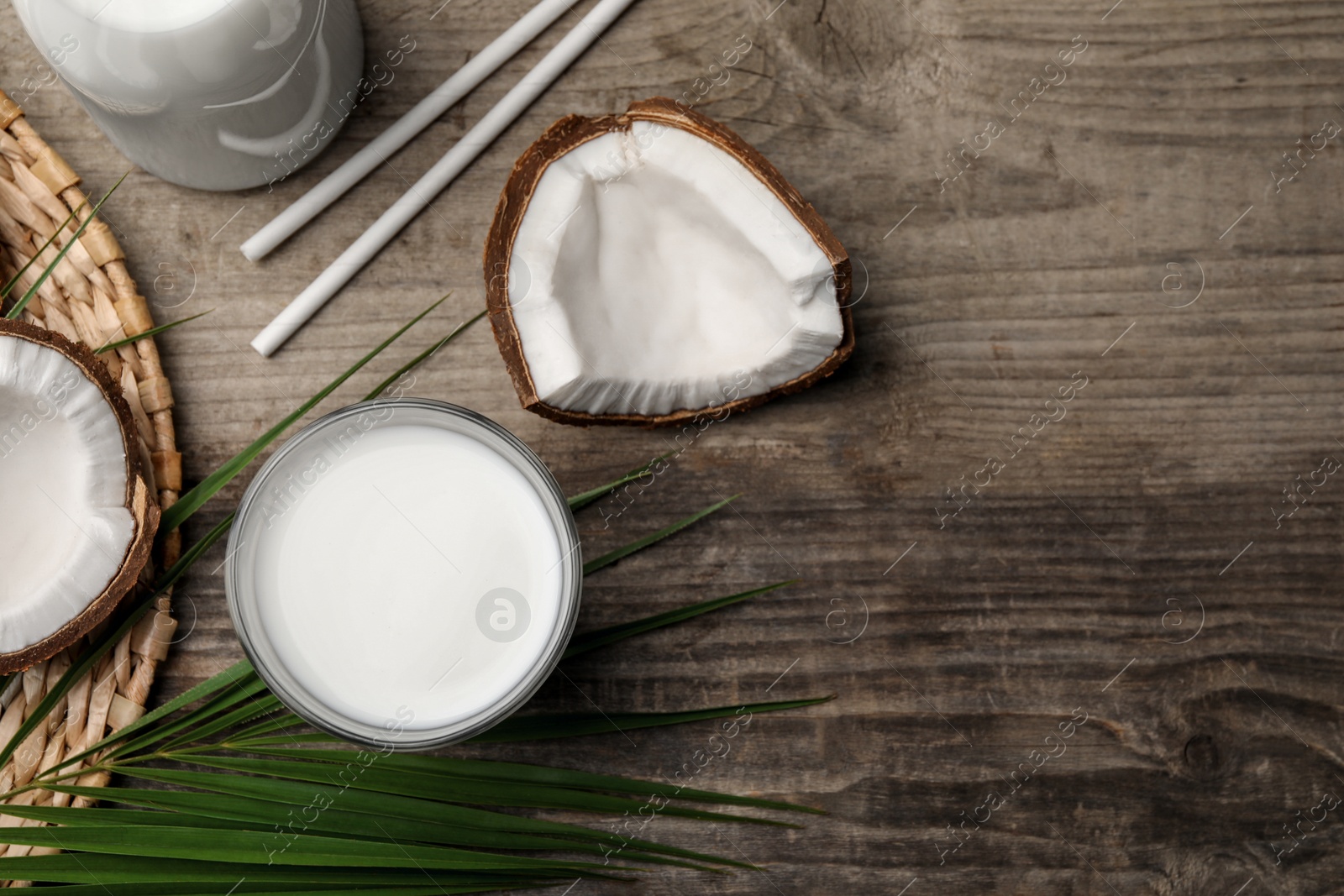 Photo of Delicious vegan milk and coconuts on wooden table, flat lay. Space for text
