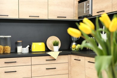 Photo of Flowers in stylish kitchen interior, selective focus