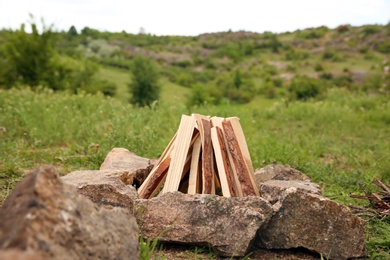 Photo of Dry wood arranged for bonfire outdoors. Camping season