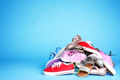 Photo of Heap of different shoes on color background. Space for text