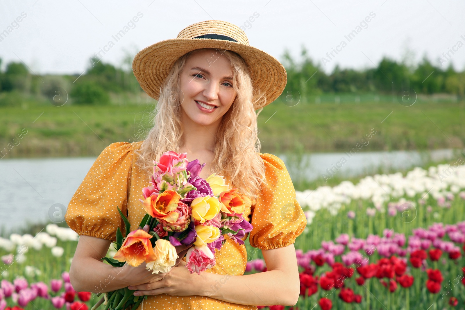 Photo of Happy woman with spring bouquet of flowers in beautiful tulip field on sunny day