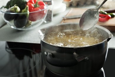 Cooking pasta in pot on electric stove, space for text