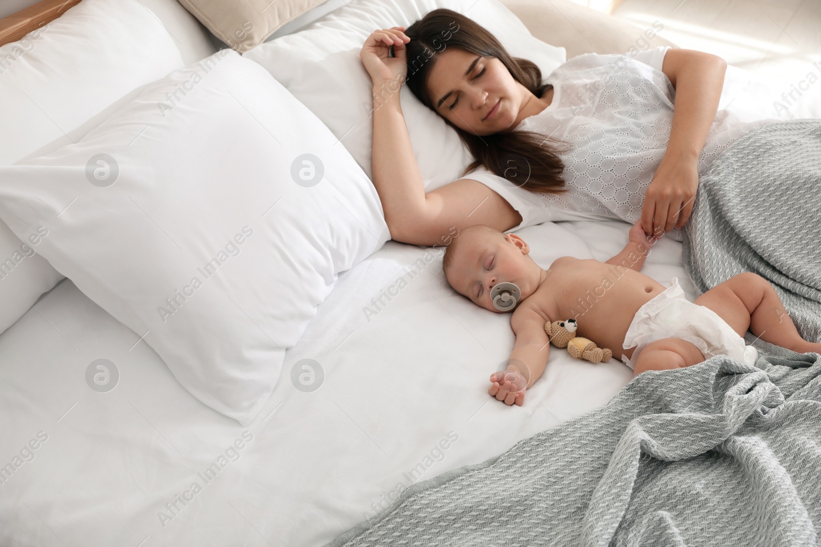 Photo of Mother with her cute baby sleeping in bed