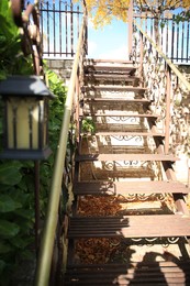 View of old metal stairs with handrails near brick wall outdoors