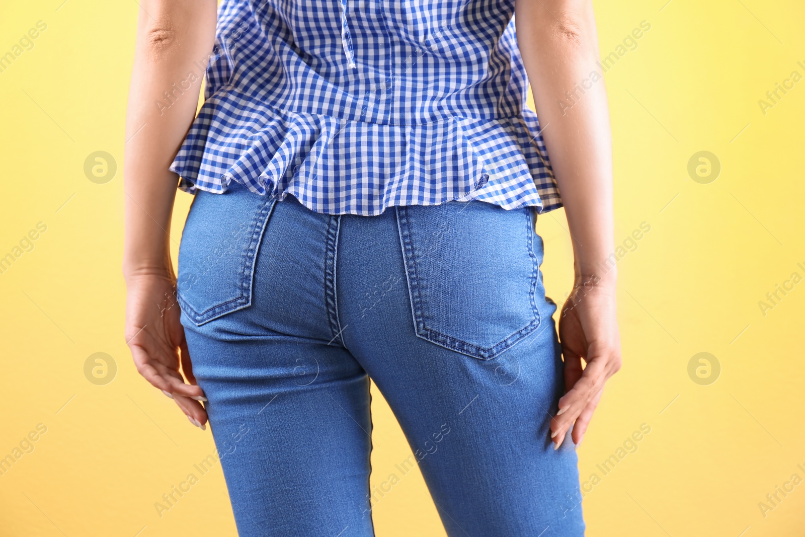 Photo of Woman in stylish blue jeans on color background