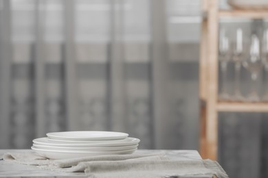 Stacked clean dishes and towel on white marble table indoors