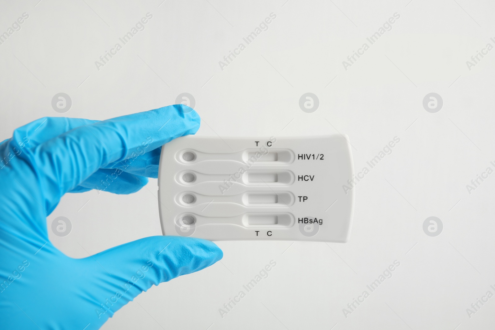 Photo of Doctor holding disposable express test for hepatitis on white background, closeup