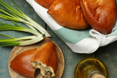 Photo of Delicious baked patties with meat, mushrooms and onion on blue wooden table, flat lay