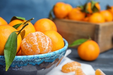 Fresh ripe tangerines in bowl on table. Space for text