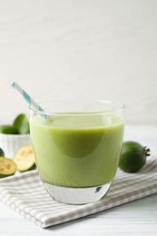 Fresh feijoa smoothie in glass on white wooden table, closeup