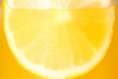 Glass of refreshing drink with sliced lemon on light background, closeup