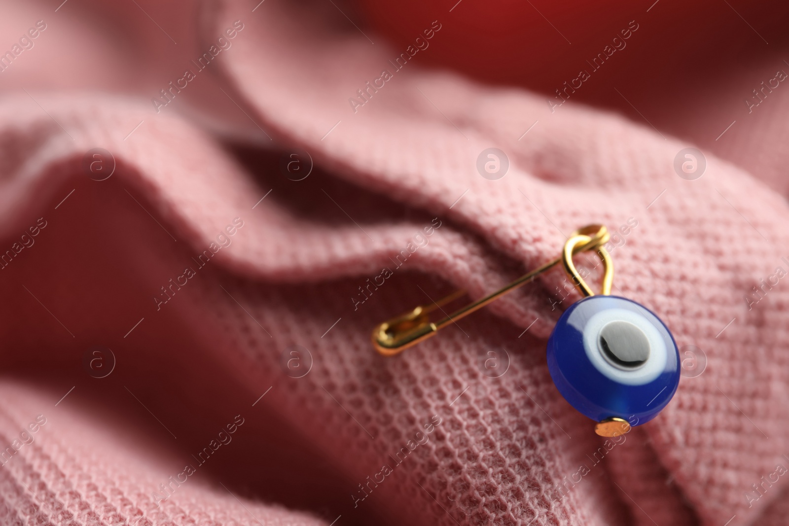 Photo of Evil eye safety pin on clothing, closeup