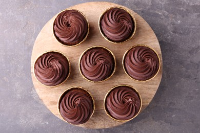 Delicious chocolate cupcakes on grey textured table, top view