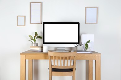 Home workplace. Computer, stationery and houseplants on wooden desk