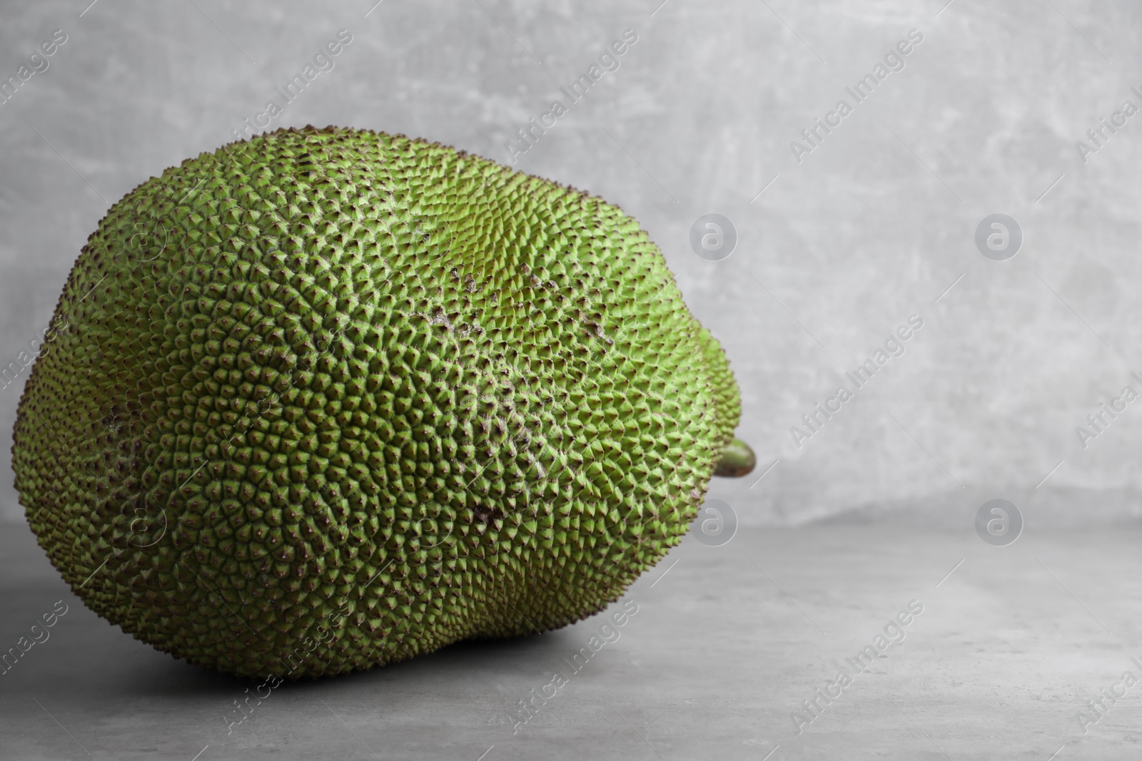 Photo of Delicious exotic jackfruit on light grey table. Space for text