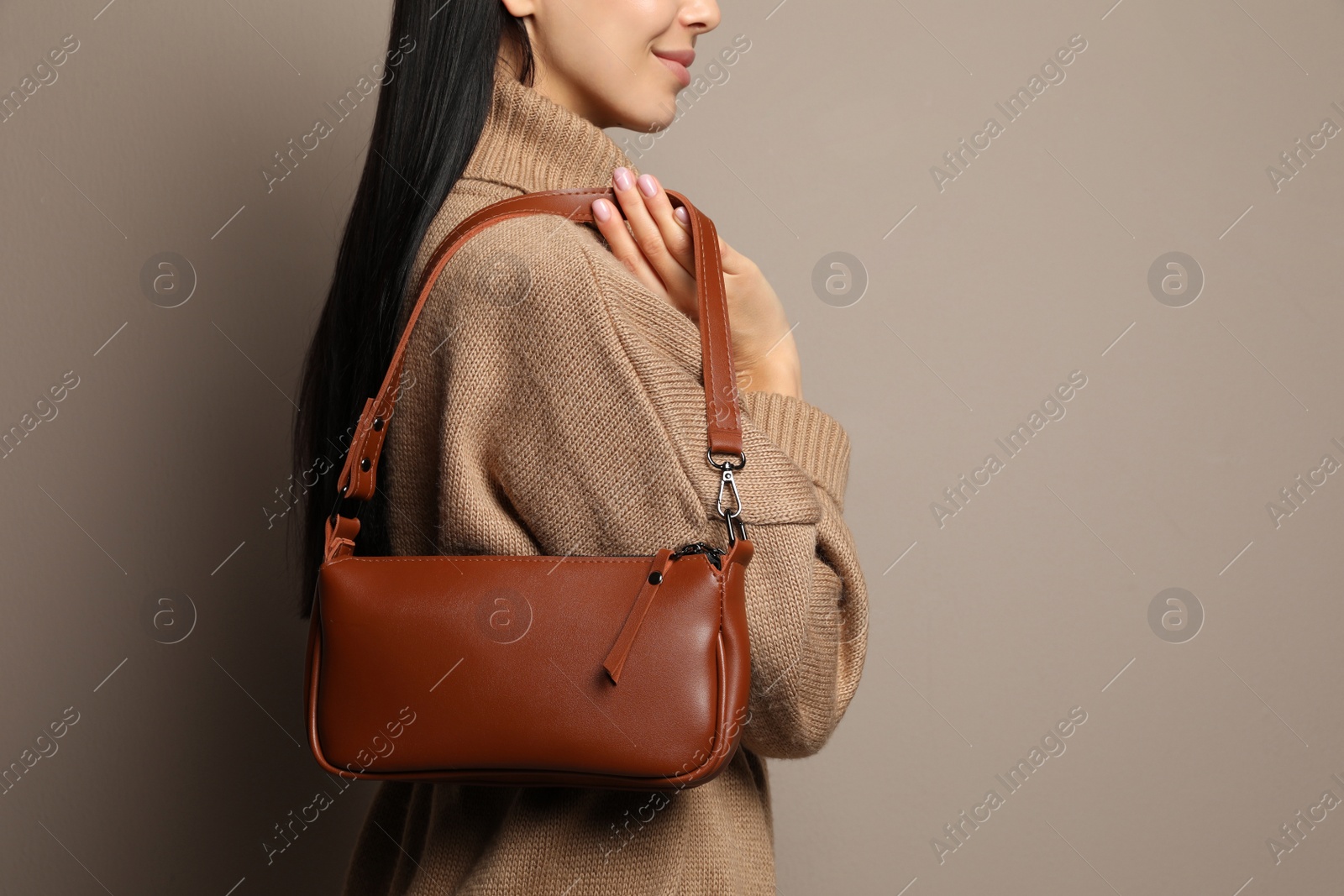 Photo of Fashionable young woman with stylish bag on beige background, closeup. Space for text