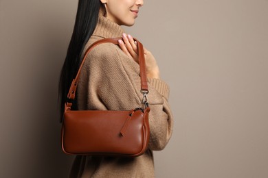 Photo of Fashionable young woman with stylish bag on beige background, closeup. Space for text