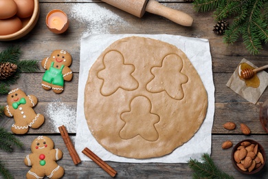 Photo of Flat lay composition with homemade gingerbread man cookies on wooden table