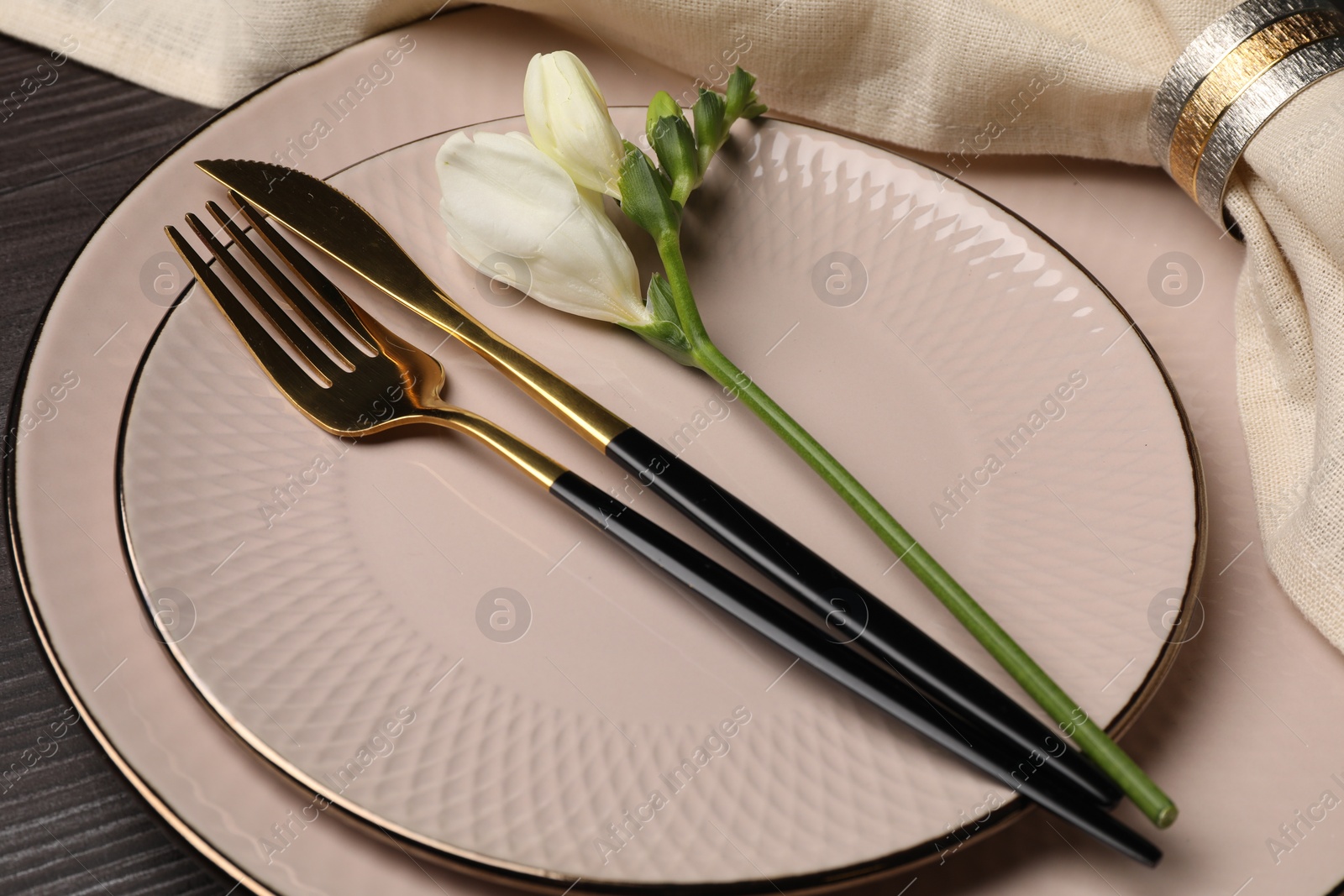 Photo of Stylish table setting. Plates, cutlery, napkin and floral decor on background, closeup