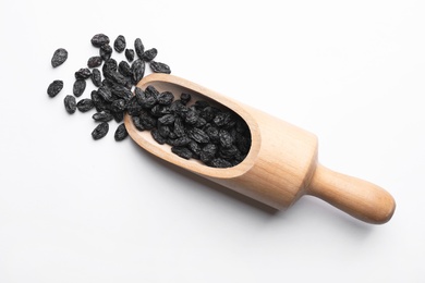 Photo of Scoop with raisins on white background, top view. Dried fruit as healthy snack