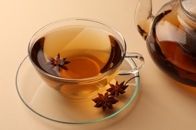 Photo of Aromatic tea with anise stars on beige background