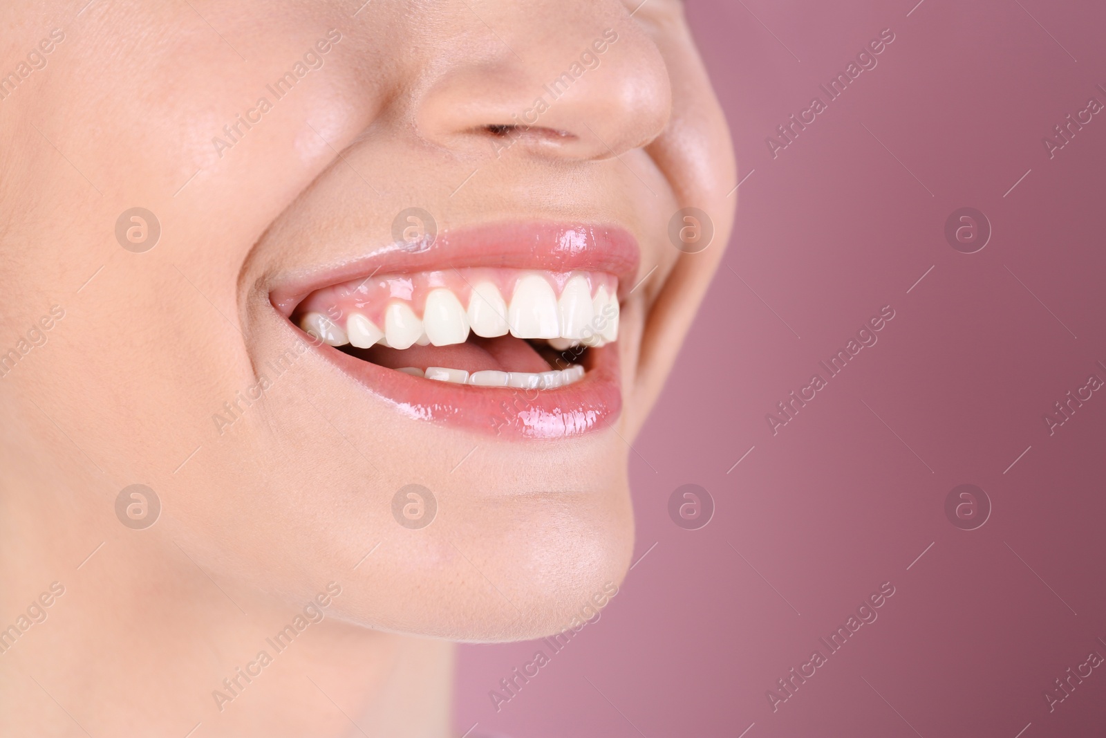 Photo of Young woman with healthy teeth and beautiful smile on color background, closeup. Space for text