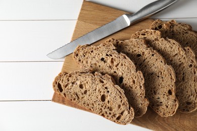 Photo of Freshly baked cut sourdough bread on white wooden table, top view. Space for text