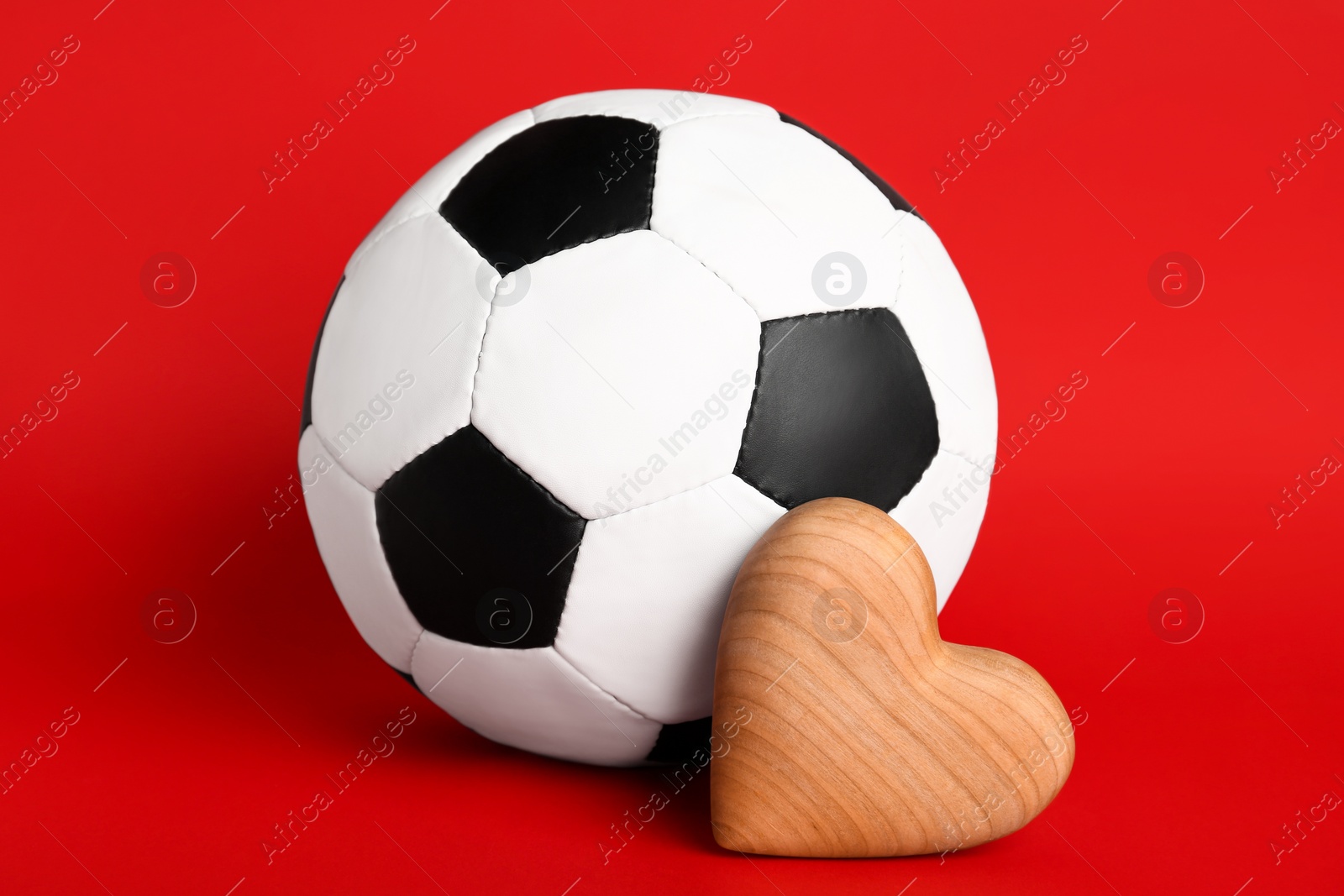 Photo of Soccer ball and heart on red background