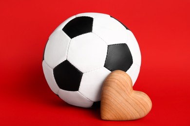 Soccer ball and heart on red background