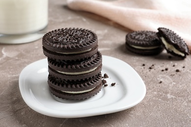 Photo of Plate with chocolate and cream cookies on table. Space for text