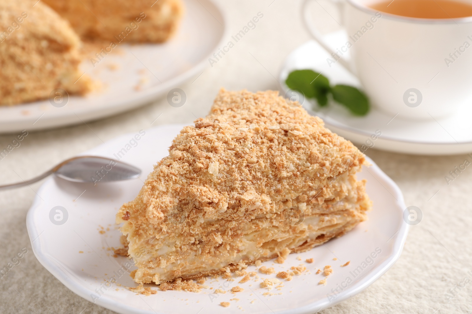 Photo of Piece of delicious Napoleon cake served on table, closeup