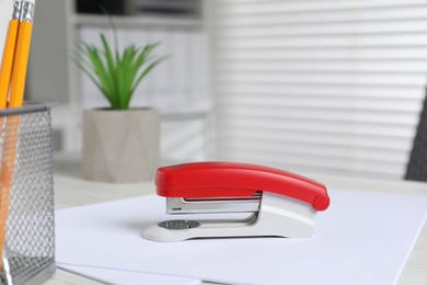 Bright stapler and papers on table indoors