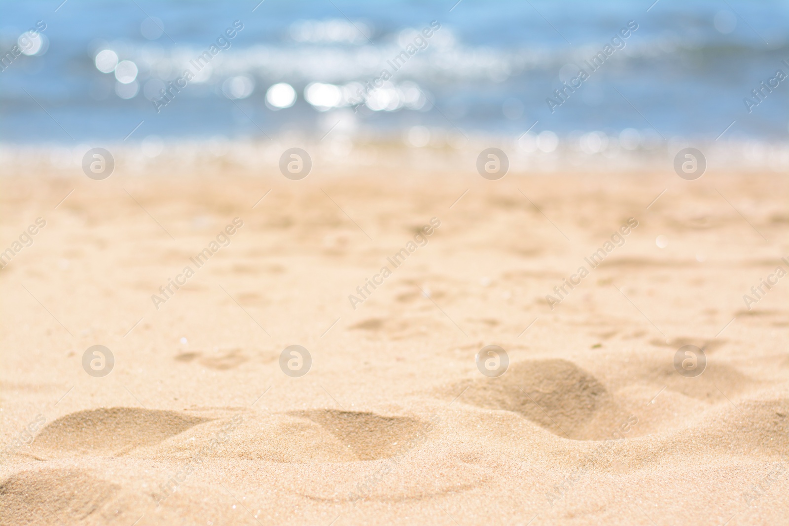 Photo of Sandy beach near sea on sunny day, closeup