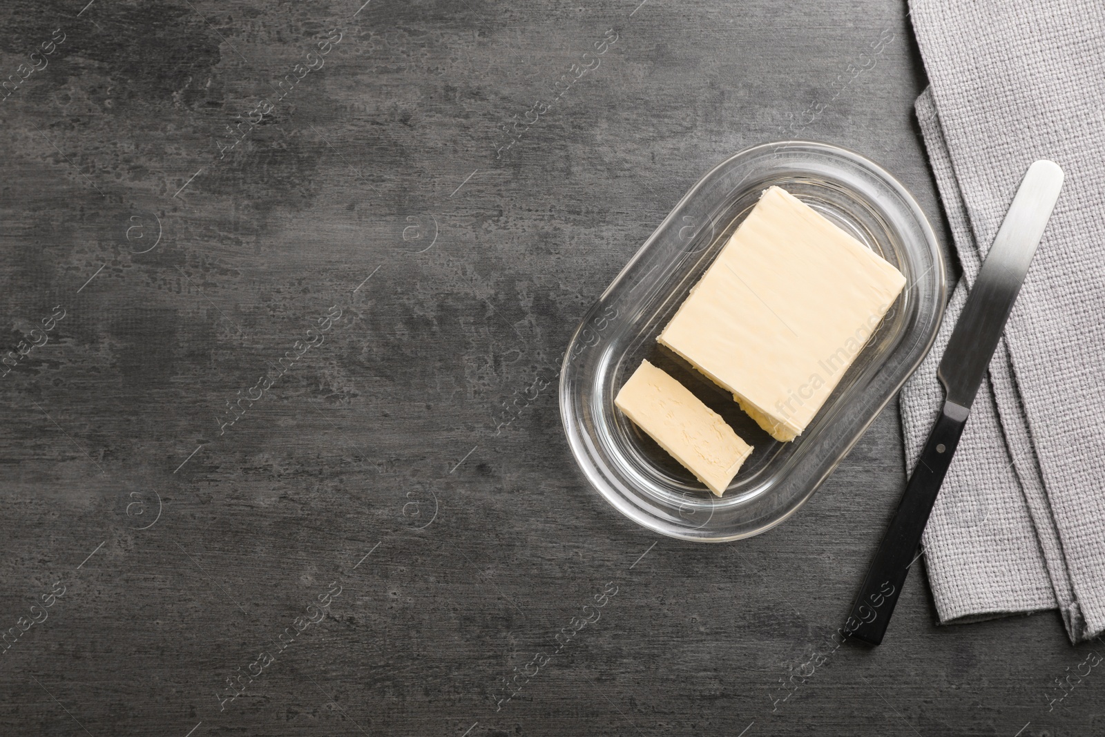 Photo of Plate with tasty fresh butter and knife on table, top view