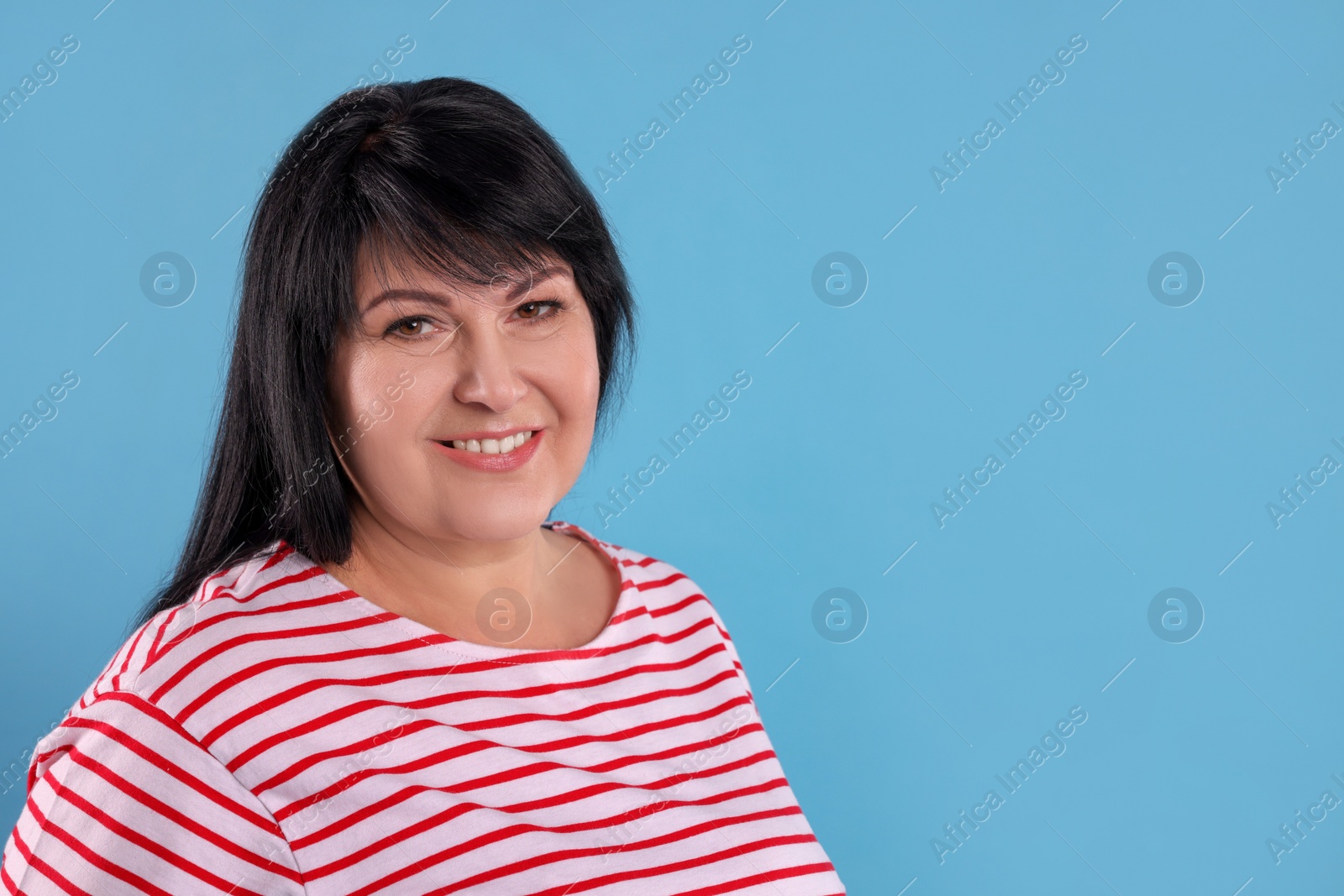 Photo of Beautiful overweight mature woman with charming smile on turquoise background. Space for text