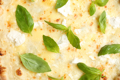 Photo of Delicious cheese pizza with basil as background, closeup