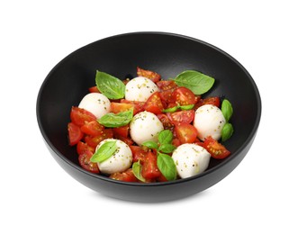 Photo of Bowl of tasty salad Caprese with tomatoes, mozzarella balls and basil isolated on white