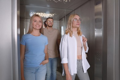 Group of young people in modern elevator